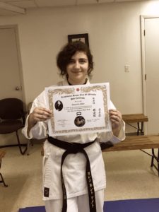girl holding black belt promotion certificate